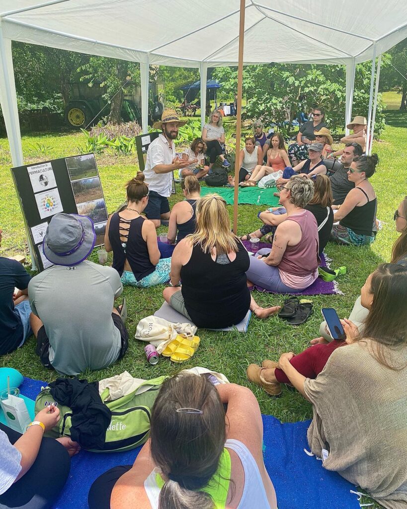 Joshua Riley speaking to a group outdoors under a canopy