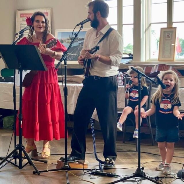 Two adults playing music with two young children indoors